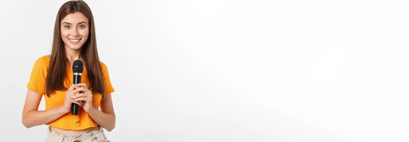 Молодая симпатичная женщина, радостная и мотивированная, поёт в микрофон, ведя мероприятие или...